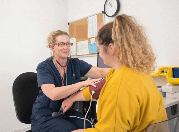 nurse with patient taking blood pressure